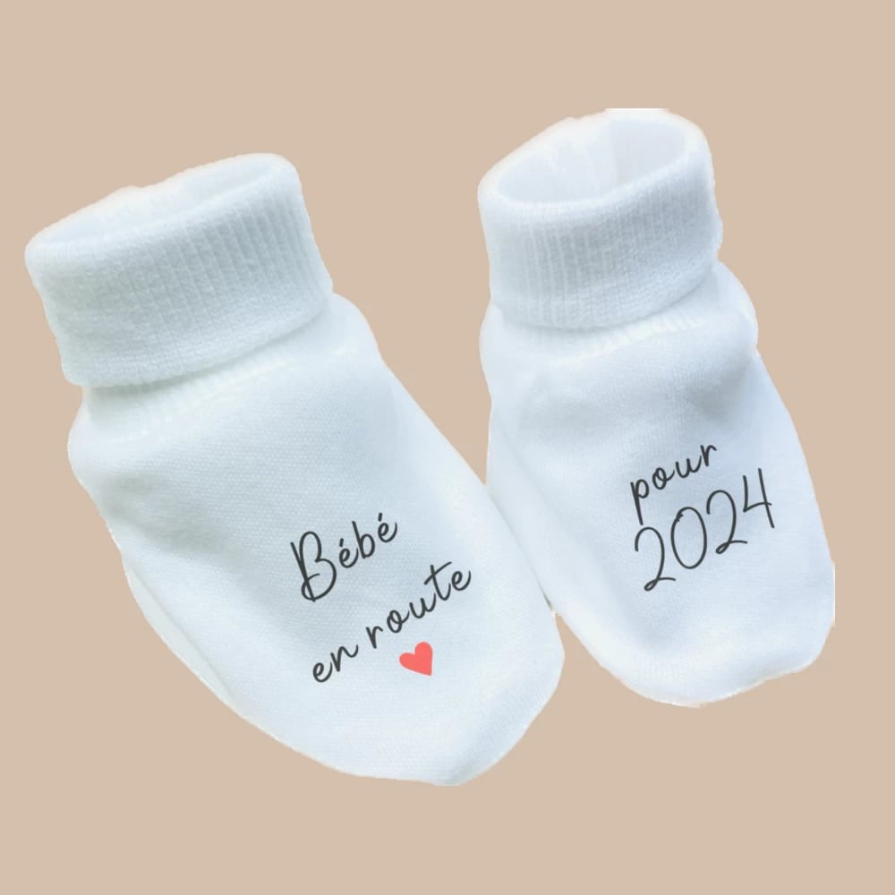 White baby booties with the message "Bébé en route pour 2024" as a creative pregnancy announcement